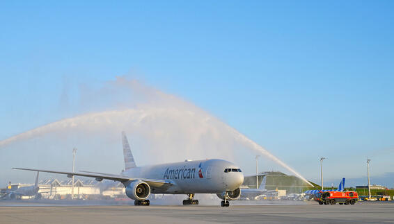 Terminal 1 Pier Successfully Put Into Operation An airplane with “American” written on it is being hosed down by a fire truck